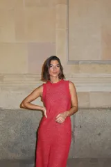 Vestido largo de punto con brillo color rojo, sin mangas, con cuello redondo y detalles de volados sutiles en los hombros.