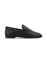 Mocasín de cuero negro con diseño entrelazado, detalle de herraje metálico en el empeine y suela plana de goma.