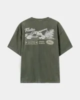 Remera oversize de color verde militar con efecto acid wash y diseño estampado en la espalda que incluye un camión de remolque y texto alusivo.