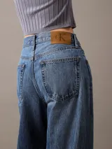 Pantalón de jean corte relaxed de pierna ancha, con diseño clásico de cinco bolsillos, cierre de botón y cremallera, en un lavado azul medio.