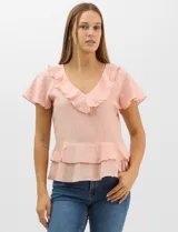 Blusa de satén color rosado con acabado texturizado, escote en V con volados, mangas cortas acampanadas y diseño péplum de doble nivel en la parte inferior.
