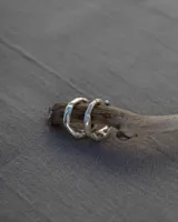 Par de aros tipo argolla de plata con textura irregular.