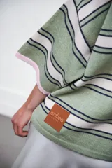 Remera rosa con rayas horizontales azul marino y bordó, cuello tipo polo marrón con botones y mangas cortas amplias.