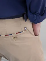 Pantalón chino de hombre color azul marino, de corte slim fit, confeccionado en gabardina de algodón, con bolsillos laterales y traseros, y cierre frontal de cremallera y botón.