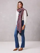 Bufandón rectangular de poliéster con estampado de arabescos en tonos rojos, azules y negros. Presenta terminaciones con flecos en los extremos.