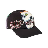 Gorro tipo cap negro con diseño bordado de una calavera y la palabra "Supreme" con apliques de pedrería roja.