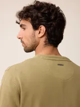 Sweater de punto con cuello en V, manga larga y puños acanalados. Presenta un pequeño logo bordado en el pecho.