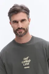 Remera de manga corta color verde oscuro con cuello redondo y estampado frontal con la frase 'OUT LIVING LIFE' y el logo de la marca Brooksfield.
