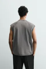 Camiseta tank gris con efecto lavado, de corte relajado, cuello redondo y manga raglán sisa.