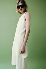 Top de Zara Woman Collection color blanco, confeccionado con mezcla de lino, con cuello redondo, espalda nadadora y diseño de bajo asimétrico.