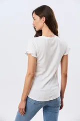 Remera de algodón color verde menta, con escote redondo y mangas corta con detalles de volados sutiles en los puños.