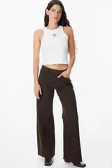 Jean de corte recto y tiro medio, color azul, con detalles de tachas metálicas doradas a lo largo de las costuras laterales externas.