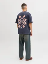 Remera oversize gris oscuro de corte holgado, con cuello redondo, mangas cortas y pequeño texto estampado en el pecho.