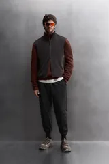 Chaleco negro de punto con interior de polar, cuello alto y cierre frontal con cremallera. Cuenta con bolsillos laterales con cierre. Zara Athleticz.