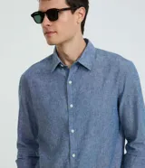 Camisa comfort de manga larga y cuello inglés, confeccionada en mezcla de lino y algodón. Presenta un diseño básico sin estampa con cierre frontal de botones.