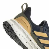 Championes de running Adidas Ultra Run 5 TR, diseñados para terrenos mixtos. Presentan un exterior de malla técnica en color azul oscuro con tratamiento repelente al agua, detalles en tono dorado y verde oliva, y una mediasuela blanca con efecto salpicado. Incluyen suela de alta tracción y tecnología de amortiguación Bounce.