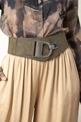 Cinto ancho color verde militar, combinado en cuero y elástico, con hebilla metálica plateada en forma de letra D.