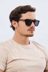 Lentes de sol polarizados de diseño rectangular con armazón negro y cristales oscuros.