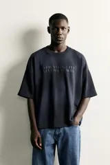 Camiseta de corte relajado con cuello redondo y manga corta. Presenta un diseño con bordados y estampados combinados a contraste en el frente con la inscripción 'New York City' y un efecto de lavado en la tela.