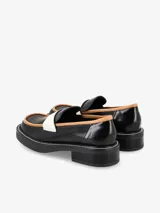 Mocasín negro de cuero con punta cuadrada, detalle en camel y tira blanca.