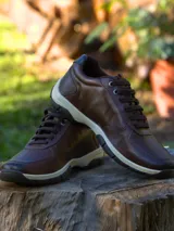 Zapato de cuero marrón con cordones y suela de goma blanca y negra.