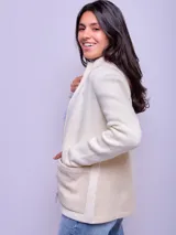 Campera de lana color crudo con cierre frontal, cuello alto y bolsillos frontales aplicados en tono beige. Presenta un diseño estructurado con espalda en paño.