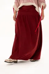 Pollera larga de corte recto con detalle de volado en la parte inferior, confeccionada en tela color bordó.