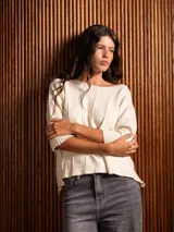 Sweater de punto color crudo con cuello alto y bordado de arabescos negros en las mangas. Corte holgado.