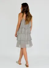 Vestido corto gris con breteles finos y volados en capas.