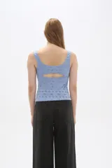 Top sin mangas confeccionado en algodón con diseño de broderie, corte al cuerpo y escote redondo con detalle de puntilla en los bordes.