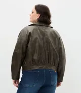 Campera bomber de cuero sintético color verde oliva, con cuello inglés, cierre frontal con cremallera, bolsillos laterales y bolsillos frontales con solapa.