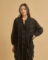 Túnica blanca de algodón con cuello mao, botones frontales y tajos laterales.