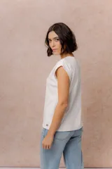 Remera de algodón color crema, con cuello redondo y mangas cortas con dobladillo vuelto. Presenta un corte relajado y estructura en los hombros.