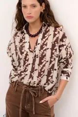 Blusa estampada en tonos marrón y crudo, de corte holgado, con cuello camisero, escote en V y mangas largas.