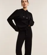 Pantalón wide leg de punto con textura acanalada, cintura elástica con lazo ajustable y detalles metalizados, y frisos verticales a lo largo de la pierna.