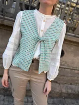 Chaleco con estampado geométrico en tonos turquesa y beige, con escote en V y lazo para ajustar en la parte delantera. Confeccionado en lino italiano reversible.