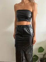 Falda midi de cuero sintético color negro, con corte recto, abertura frontal, bolsillos cargo laterales y cierre con botón y cremallera.