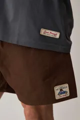 Short de gabardina color beige con calce relajado, cintura elástica con cordón ajustable y largo a mitad de muslo.