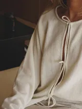 Saco negro de tejido de punto, con corte holgado y mangas largas.