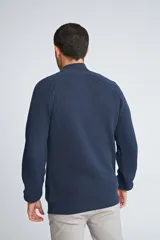 Sweater de tejido de punto acanalado en color negro, con cuello alto y cierre frontal parcial. Cuenta con mangas largas y un pequeño logo bordado en el ruedo.