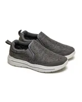 Zapatillas grises sin cordones, con elástico en los laterales y suela blanca.