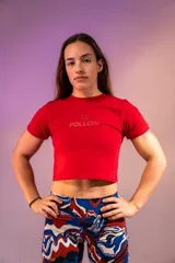 Remera corta roja ajustada al cuerpo con estampado frontal con la palabra "Follow" y un logo de alas.