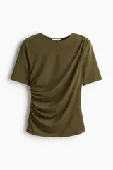Top de manga corta en punto de crepé, color verde militar, con escote redondo y diseño ajustado. Presenta frunces en un hombro y en el lado opuesto de la cintura que generan un efecto drapeado.