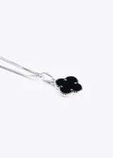 Collar plateado con dije de trébol negro con borde de pequeñas cuentas plateadas.
