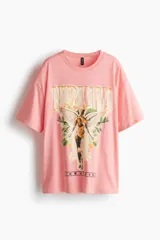 Remera oversized de algodón color rosado, de manga corta con hombros caídos, cuello redondo ribeteado y estampa frontal del álbum In Utero de Nirvana.