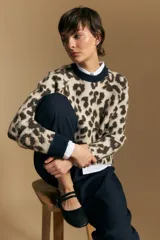 Sweater de tejido jacquard con estampado animal print, de silueta relajada y manga larga. Presenta cuello redondo y bordes en contraste de color bordó.