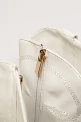 Bota de cuero negra con caña media, punta fina y taco bloque. Diseño estilo western con bordados decorativos.