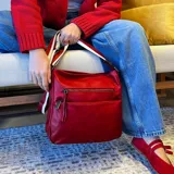 Bandolera de cuero sintético color mostaza, con dos bolsillos frontales con cierre, apertura superior con cierre, división interna y bolsillo trasero con cierre. Incluye correa larga regulable combinada en tonos mostaza y beige.