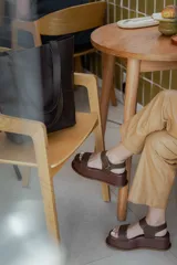 Sandalias de plataforma color negro, con diseño de dos tiras anchas en el empeine y cierre con velcro en el tobillo. Presentan una suela de plataforma alta y liviana.