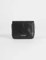 Billetera plegable de cuero vegano color negro, con cierre perimetral y placa metálica con logo en el frente.